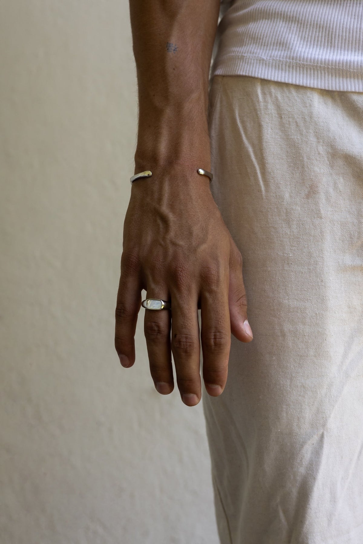 Man in linen trousers wearing the inlay signet ring