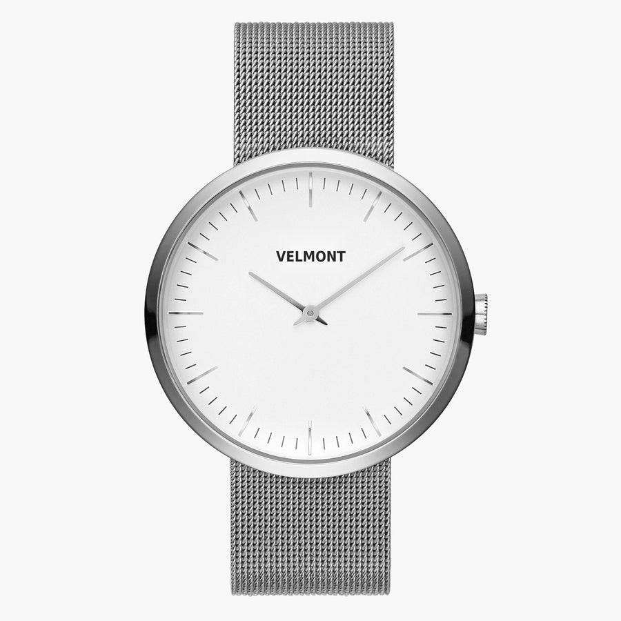 Minimalist watch with a white dial and silver-tone case on a silver-tone mesh strap.