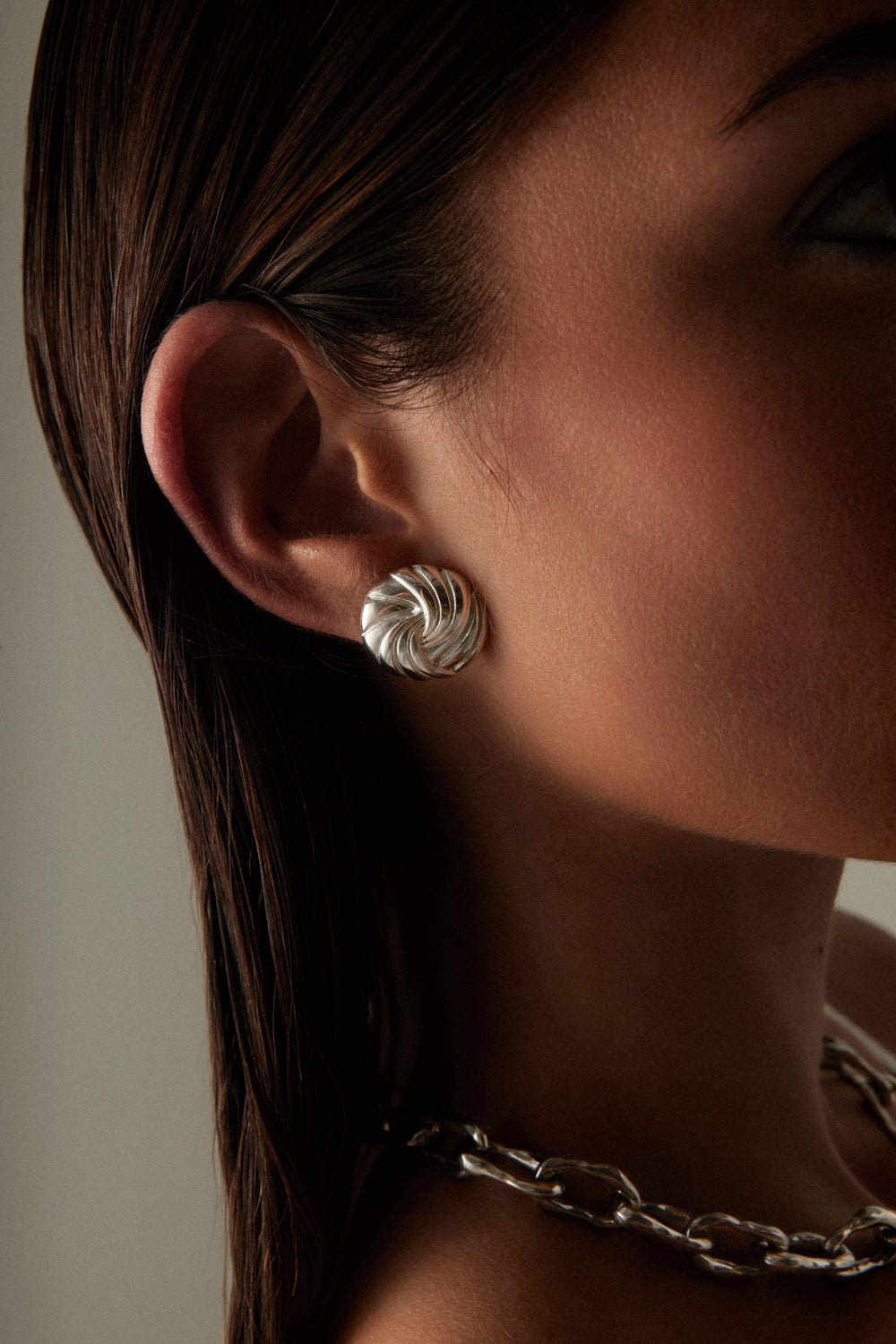 Close-up of the swirl stud worn on the ear