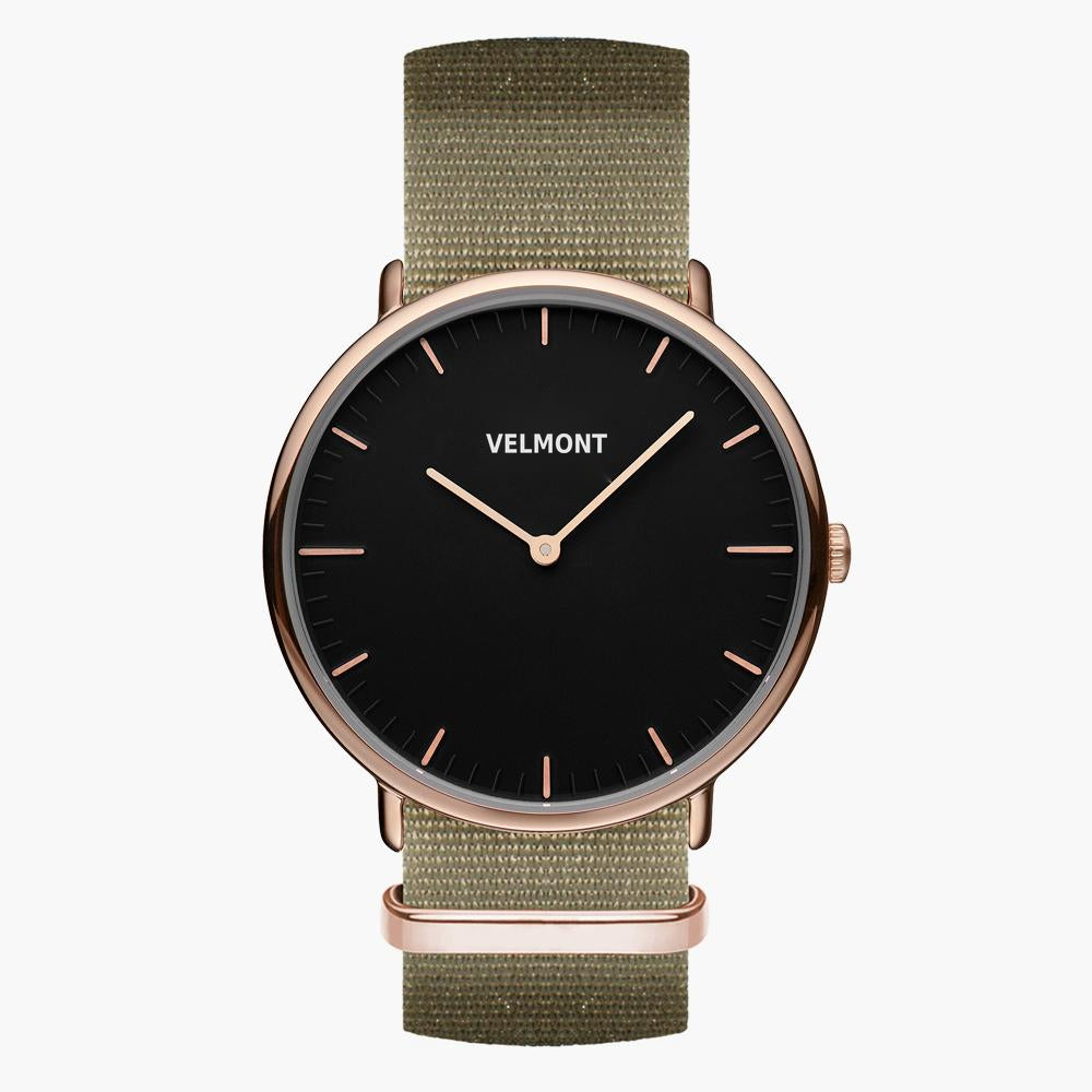 Watch with a black dial and rose gold-tone case on an olive green woven strap.
