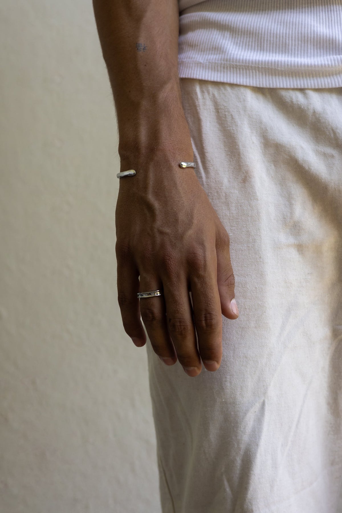 Man in linen trousers wearing the textured band ring