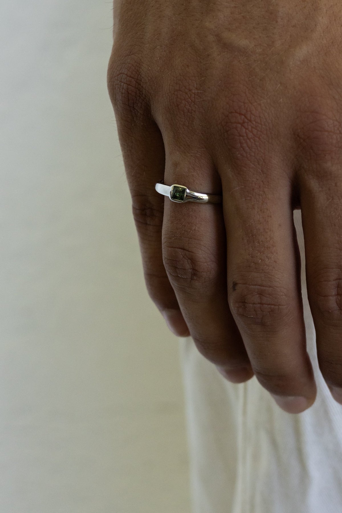 Hand wearing the square stone ring