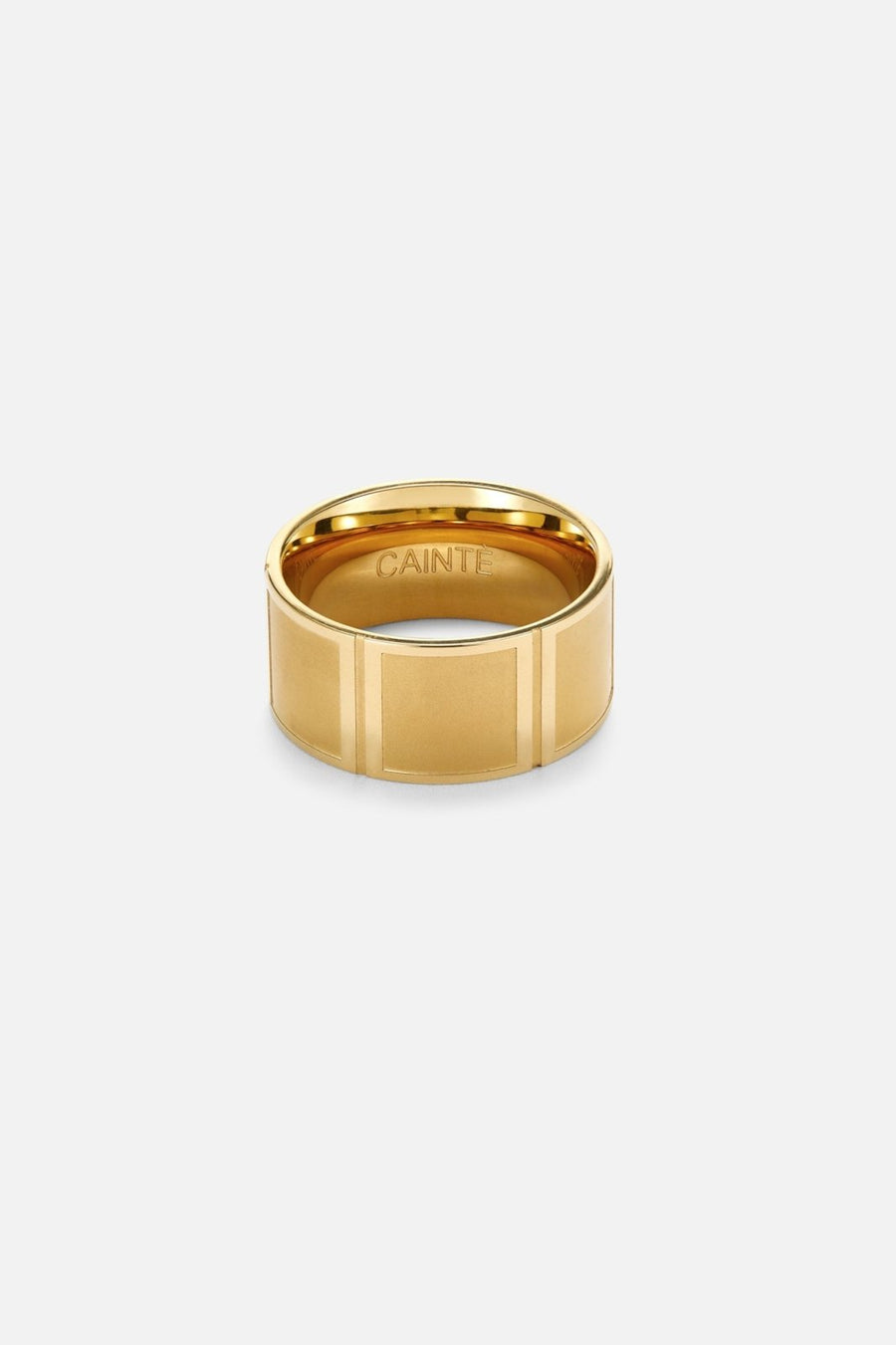 Wide gold-tone band ring, front view on a light background