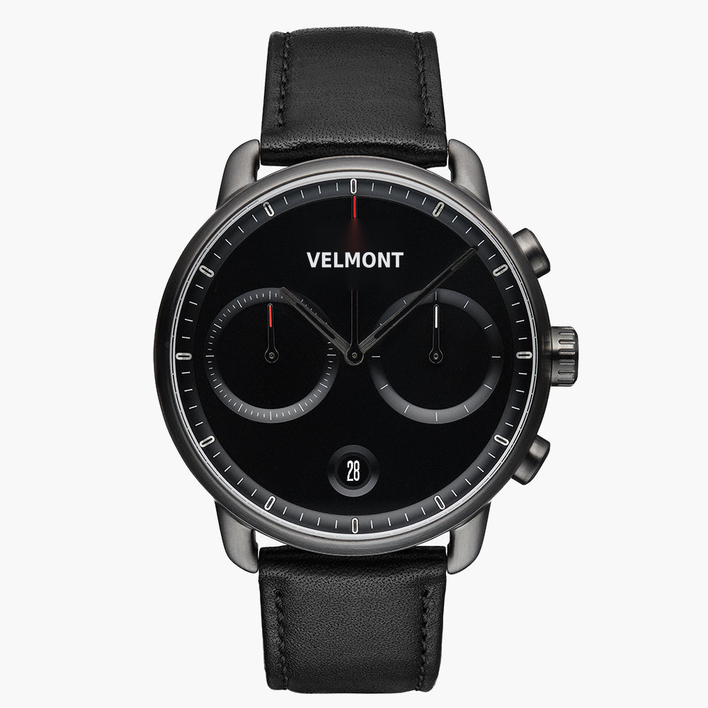 Chronograph-style watch with a black dial and gunmetal case on a black strap.