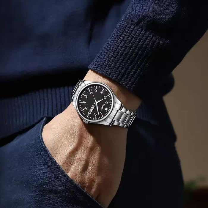 Steel watch on a wrist in a trouser pocket