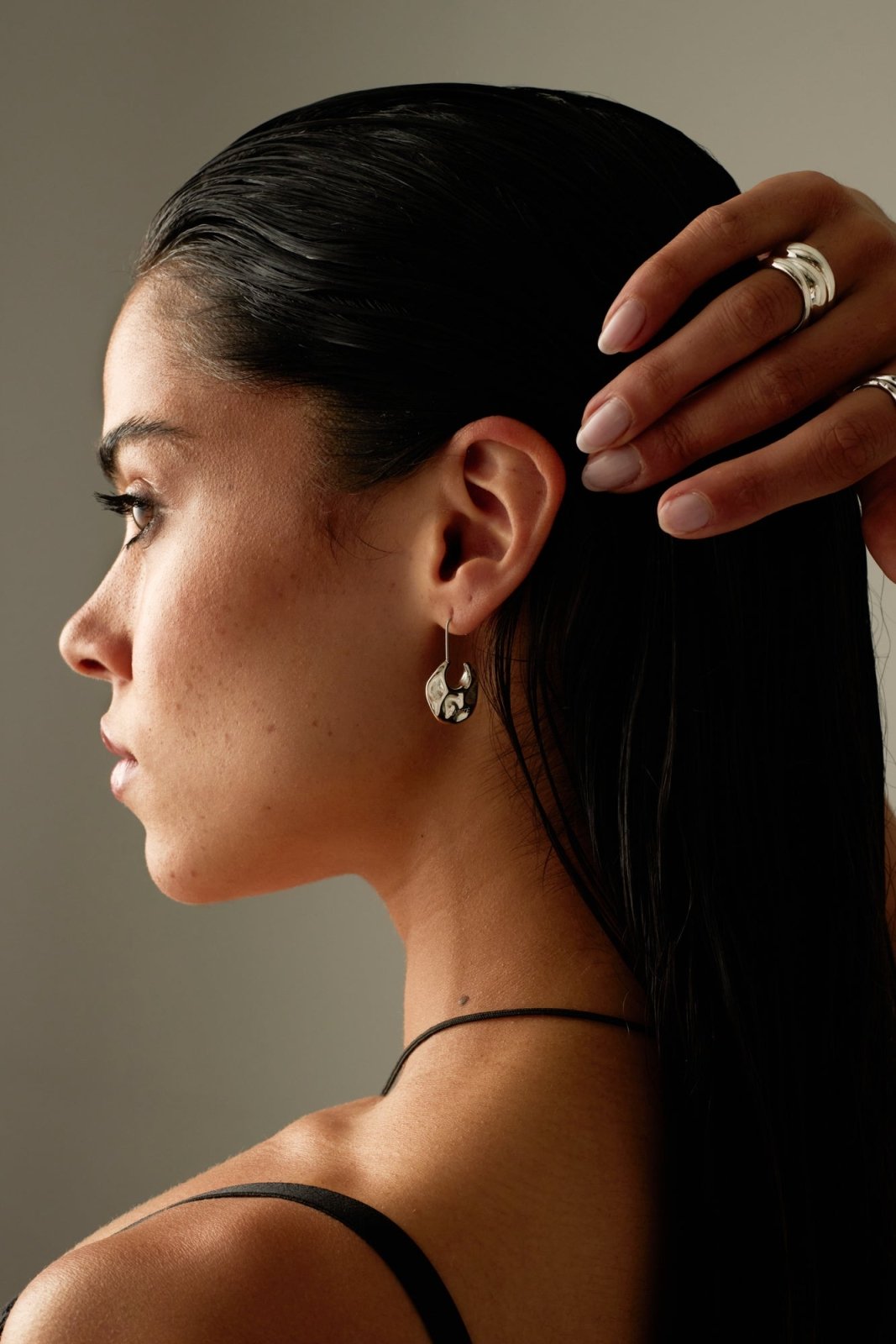 Model in profile wearing the hammered drop earring