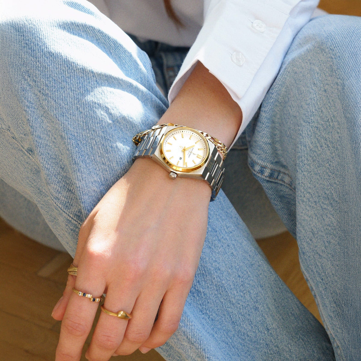 Worn with light blue jeans and a white shirt, gold rings on the fingers.