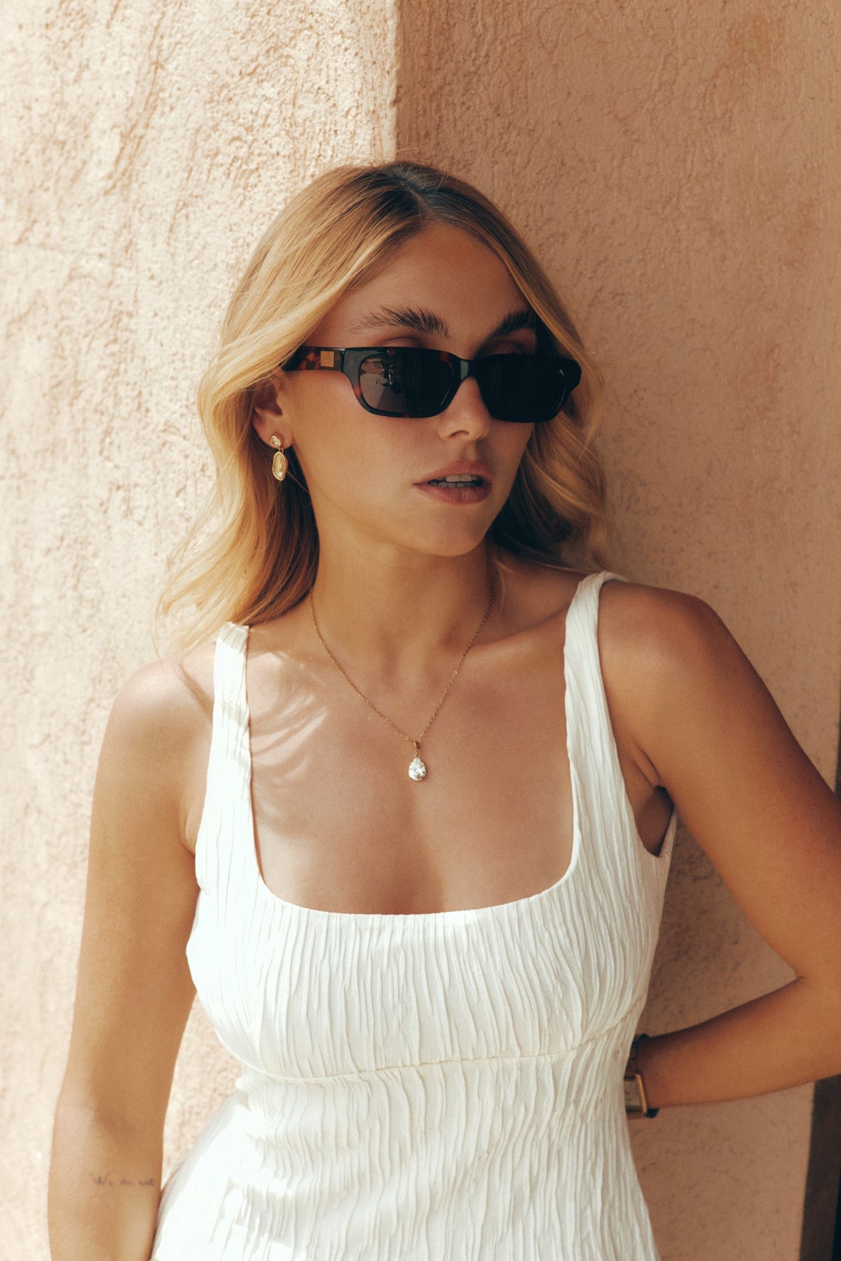 Woman in a white dress wearing the sunglasses