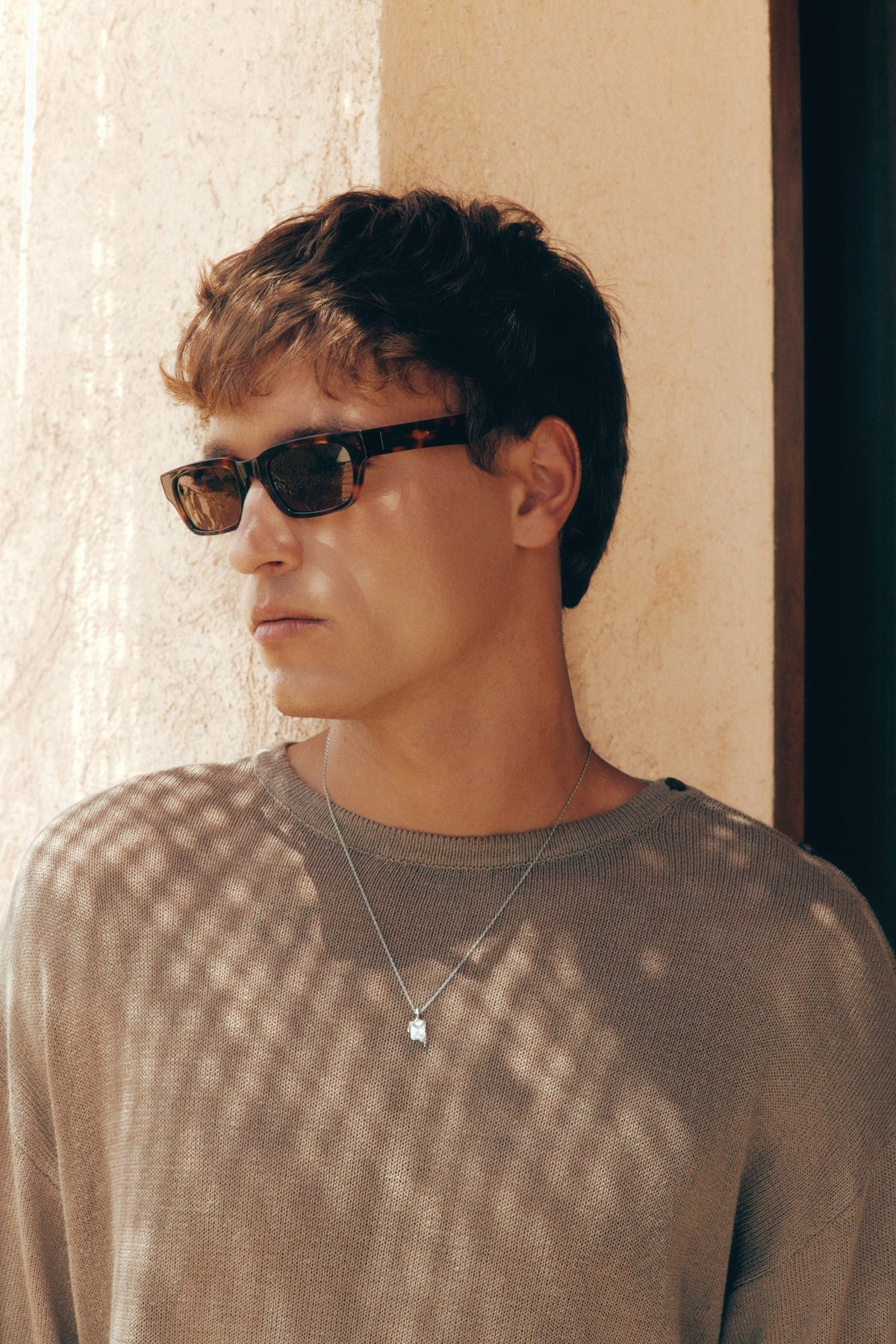 Man in a knit sweater wearing the tortoise sunglasses