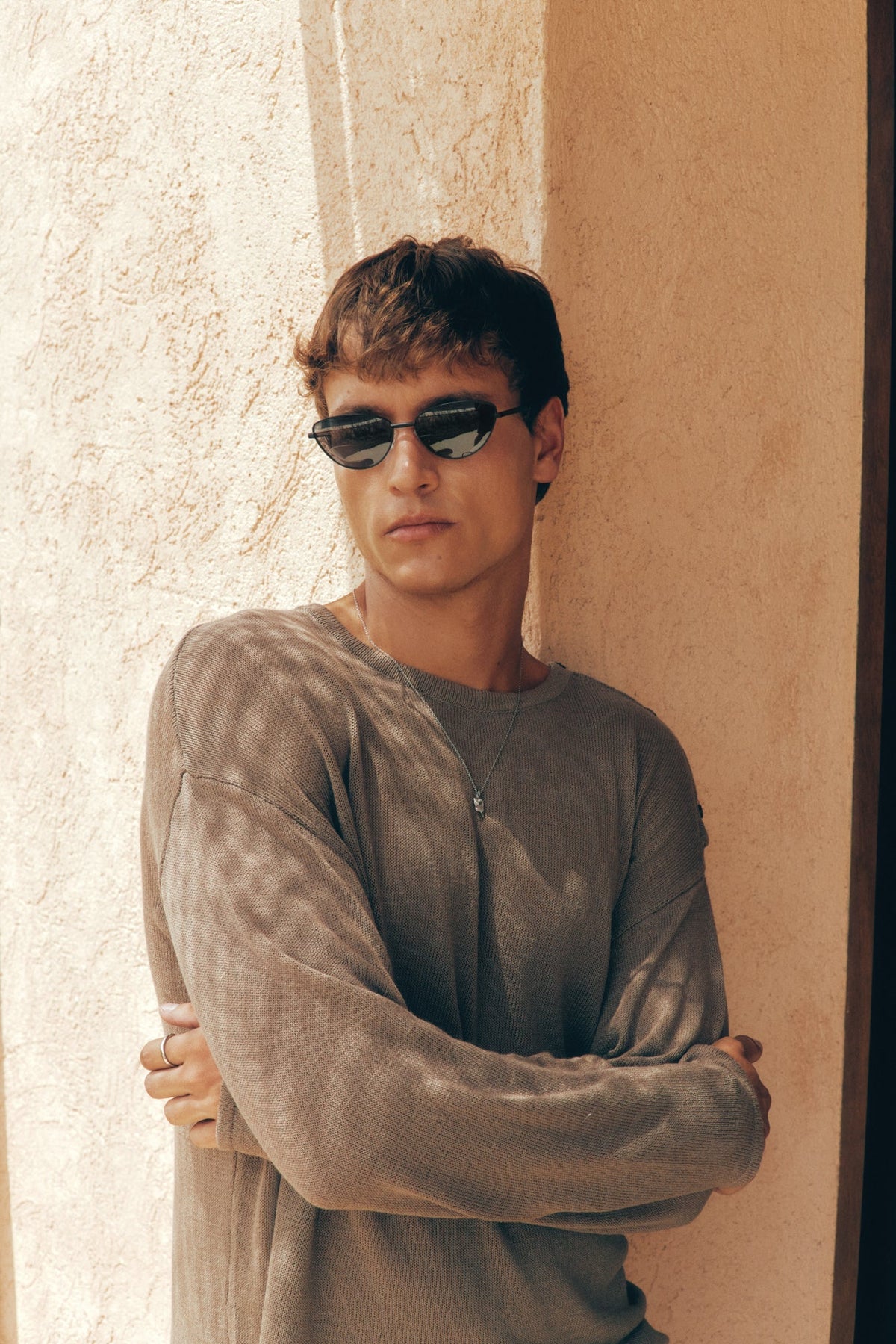 Man wearing the cat eye sunglasses against a wall