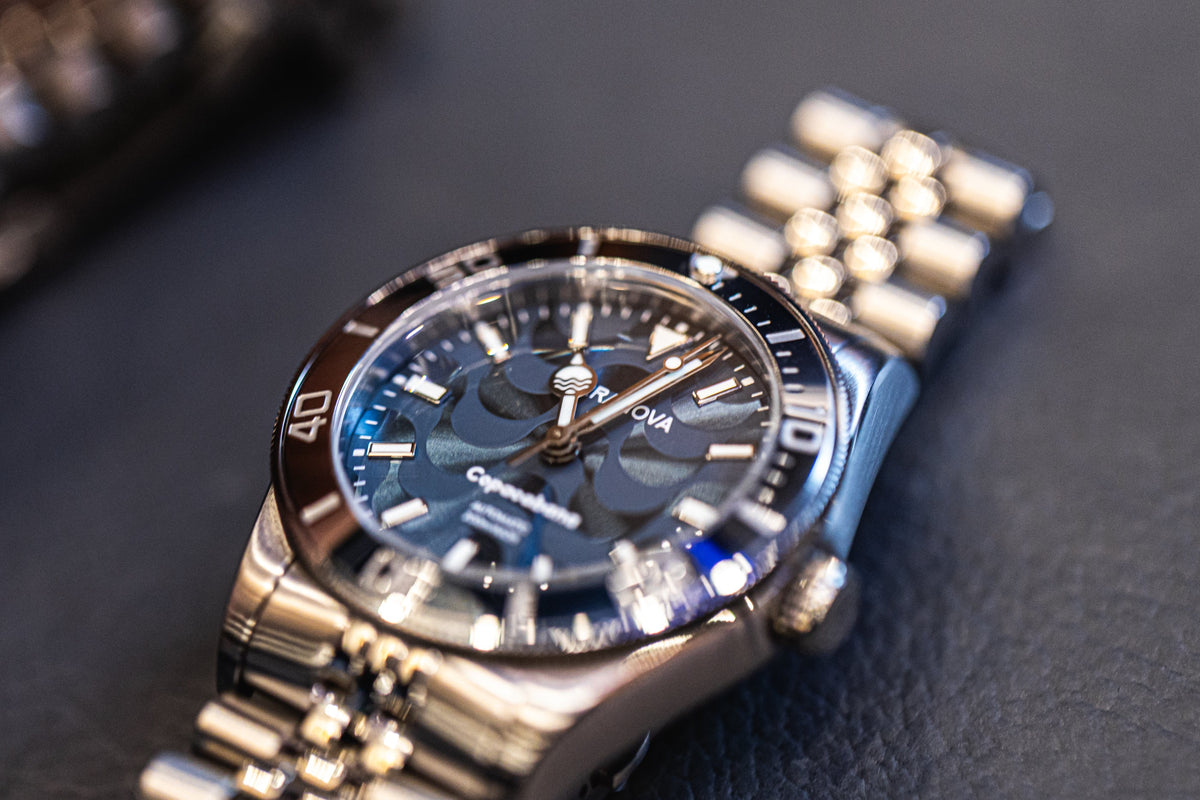 Blue dial watch on a blue surface