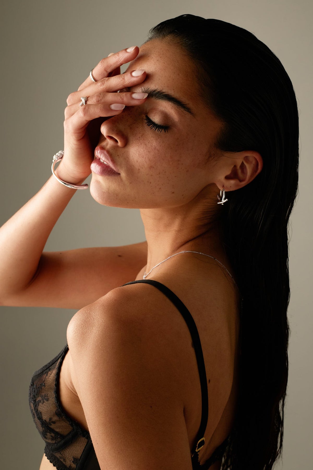 Model covering her eyes, hoop earring visible