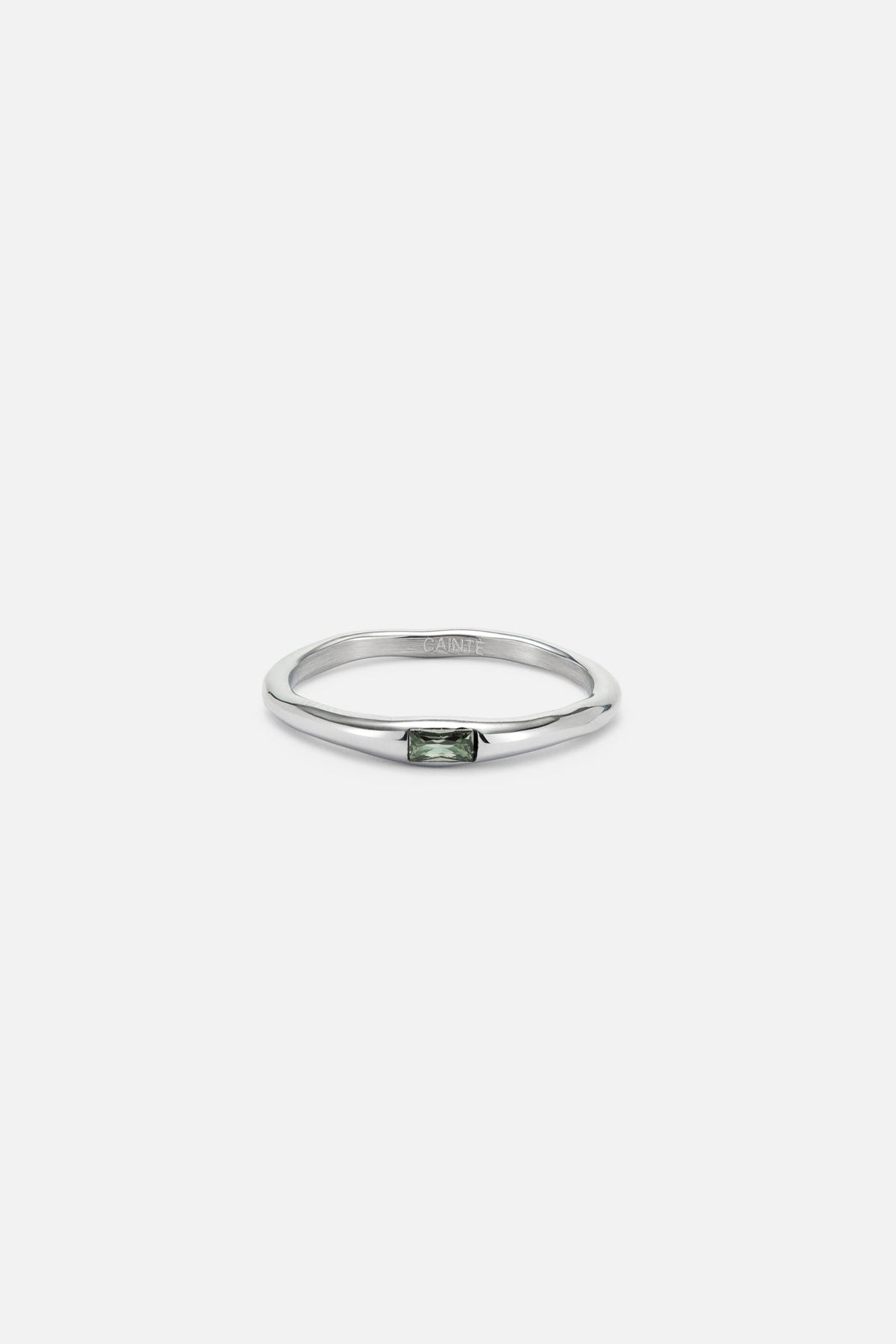 Thin band ring with a tiny green stone, front view