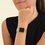 Black-dial square watch worn with a black top