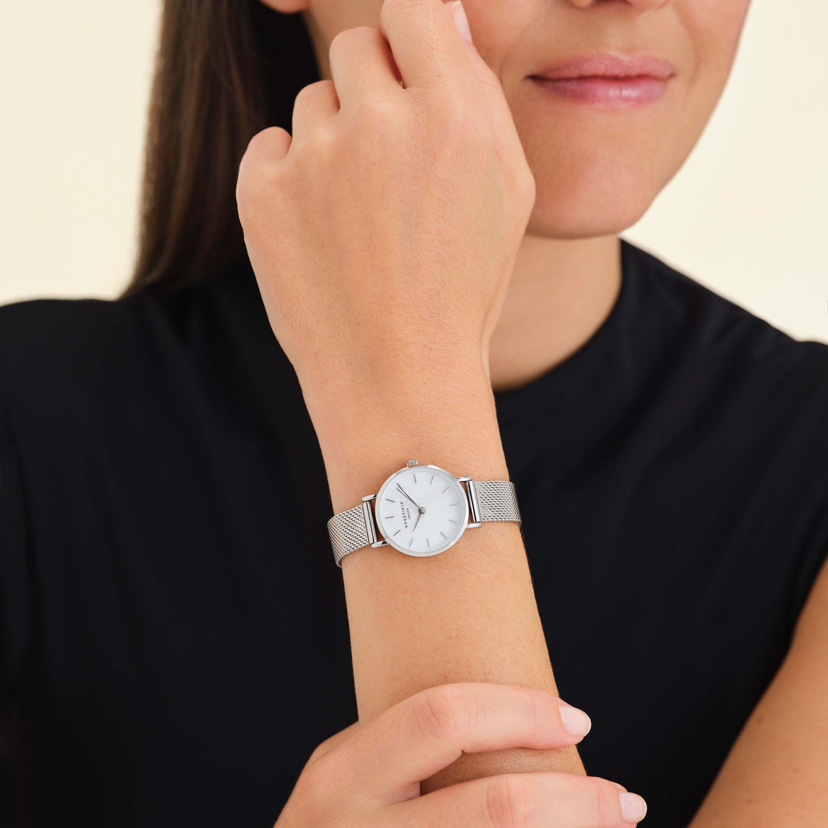 Silver-tone watch worn near the face