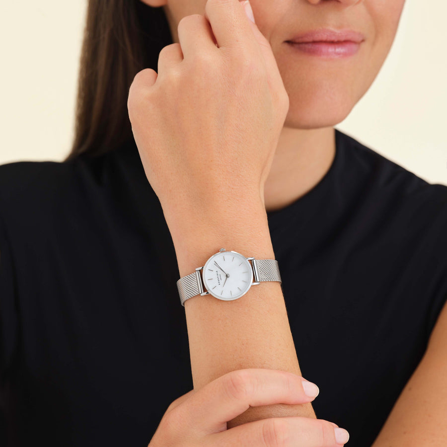 Silver-tone watch worn near the face