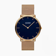 Watch with a navy blue dial and gold-tone case on a gold-tone mesh strap.