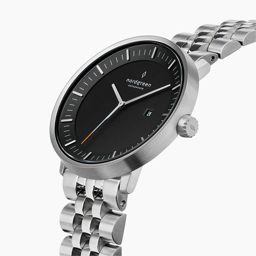 Angled view of the brushed silver-tone case, crown and black dial with date.