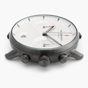 Side profile of the gunmetal case with the crown set between two pushers.