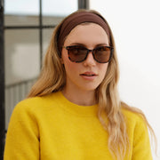 Woman in a headband and oversized sunglasses