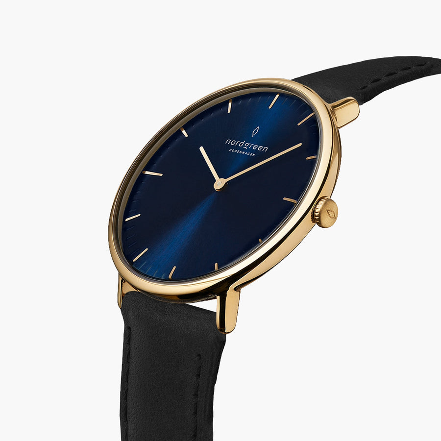Watch turned at an angle, blue sunburst dial and gold-tone bezel catching the light.