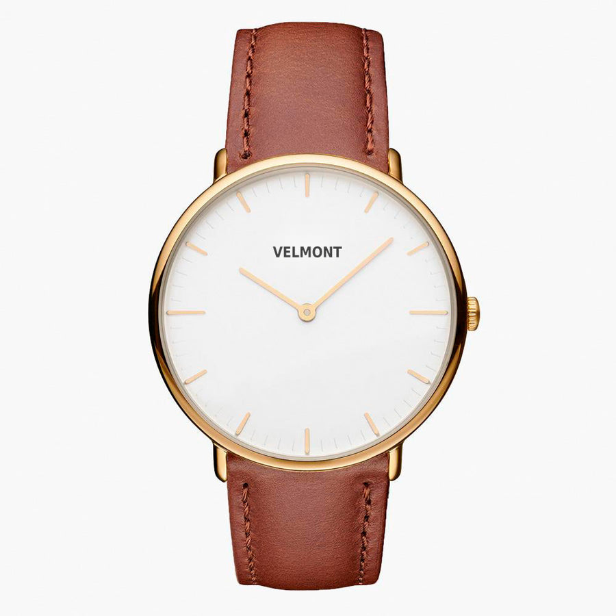 Minimalist watch with a white dial and gold-tone case on a cognac brown strap.