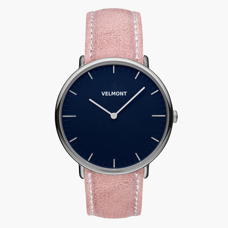 Watch with a navy blue dial and silver-tone case on a pink strap with white stitching.