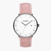 Watch with a white dial and gunmetal case on a pink strap with white stitching.