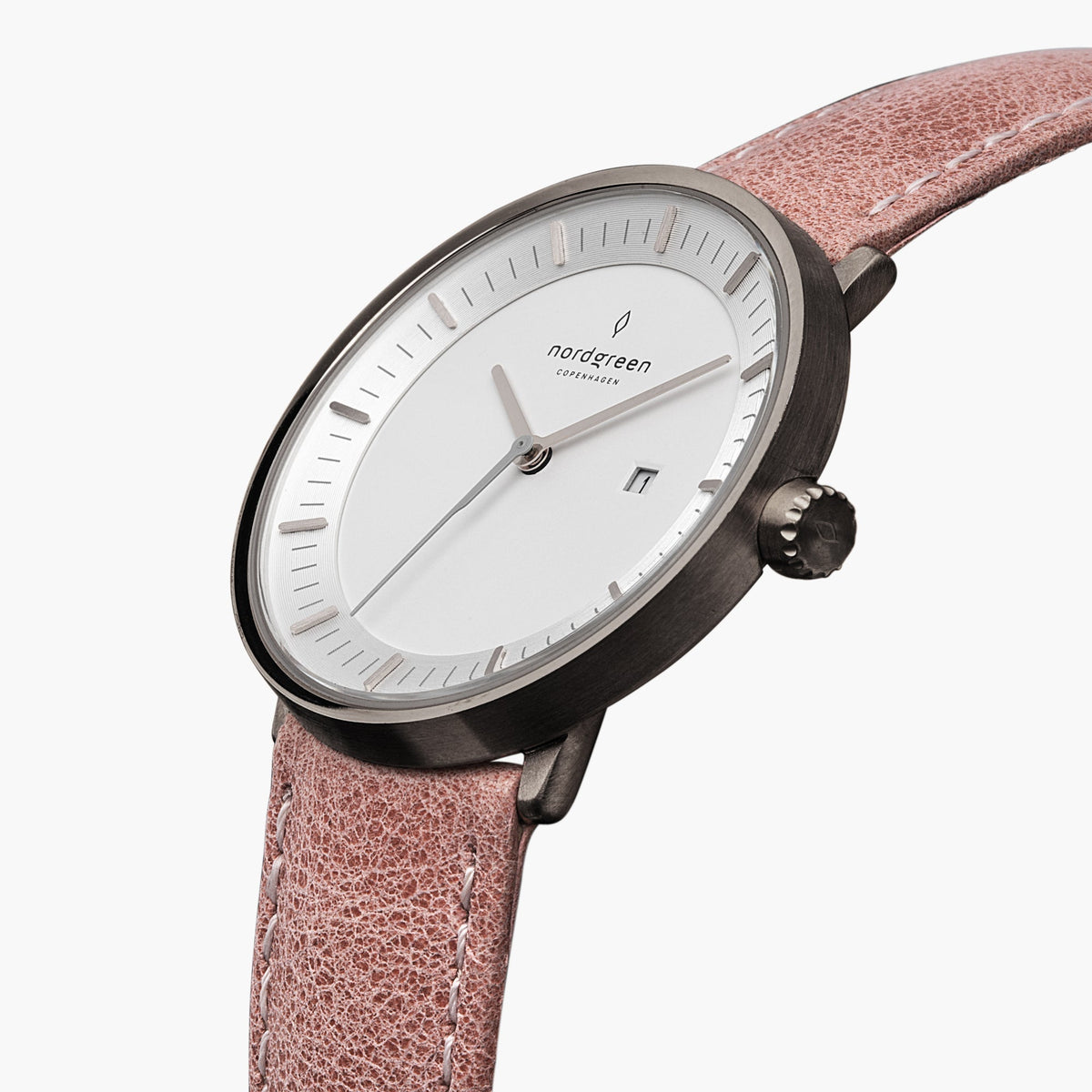Three-quarter view of the gunmetal case and date window on a dusty pink strap.