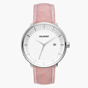Watch with a white dial and silver-tone case on a dusty pink strap.