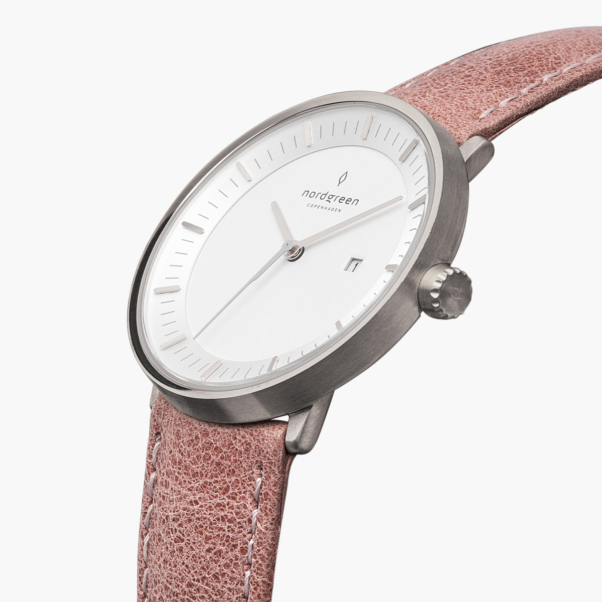 Three-quarter view of the silver-tone case and date window on a pink strap.