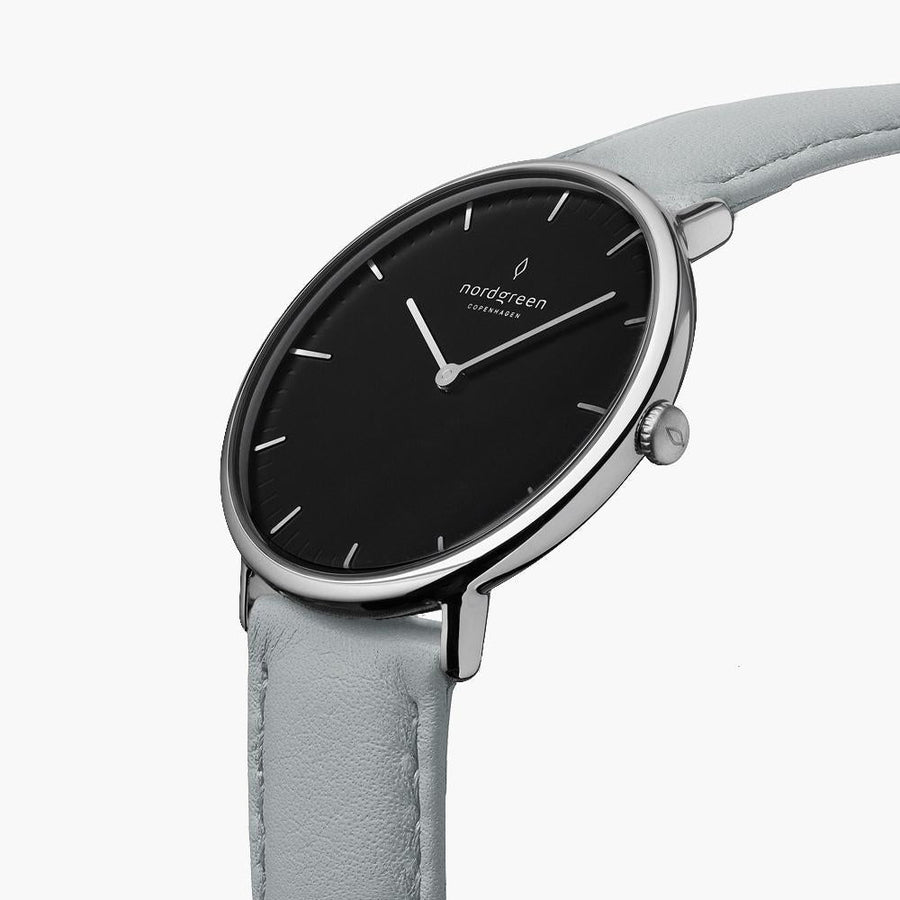 Watch turned at an angle, black dial and silver-tone bezel catching the light.