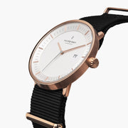 Angled view showing the date window and knurled rose gold-tone crown.