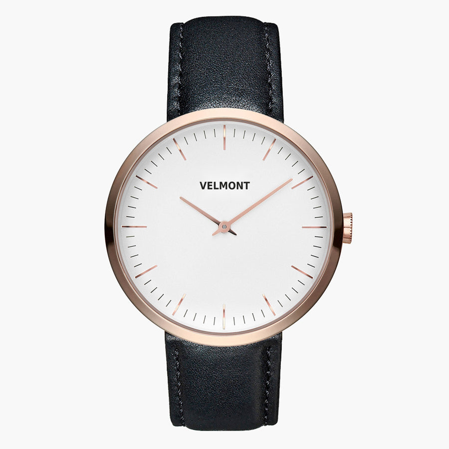 Minimalist watch with a white dial and rose gold-tone case on a black strap.
