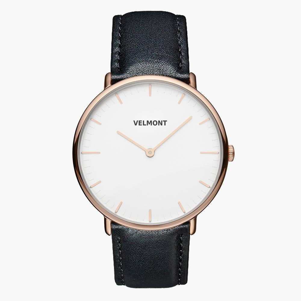 A white dial framed by a slim rose gold-tone case, set on a black strap.