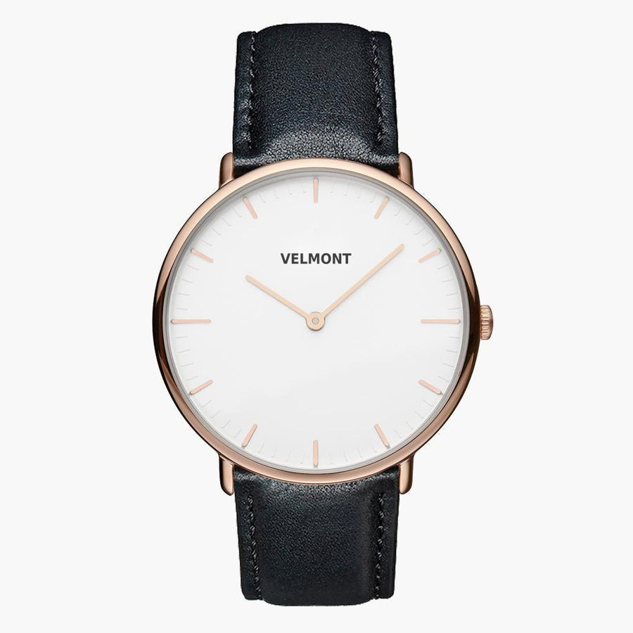 A white dial framed by a slim rose gold-tone case, set on a black strap.