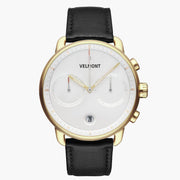 Chronograph-style watch with a white dial and gold-tone case on a black strap.