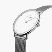 Angled view of the silver-tone case showing the crown and woven mesh.