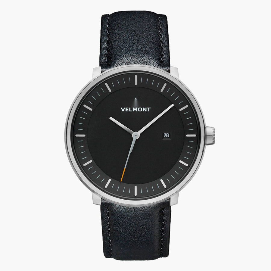 Watch with a black dial and silver-tone case on a black strap, shown from the front.