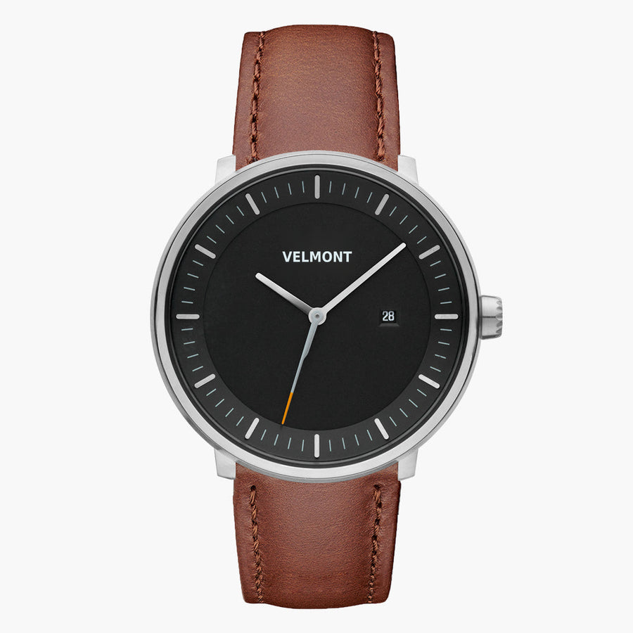 Watch with a black dial and silver-tone case on a brown strap, shown from the front.
