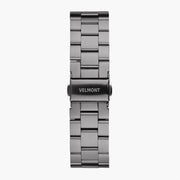 Gunmetal three-row link bracelet with a dark fold-over clasp, laid flat.