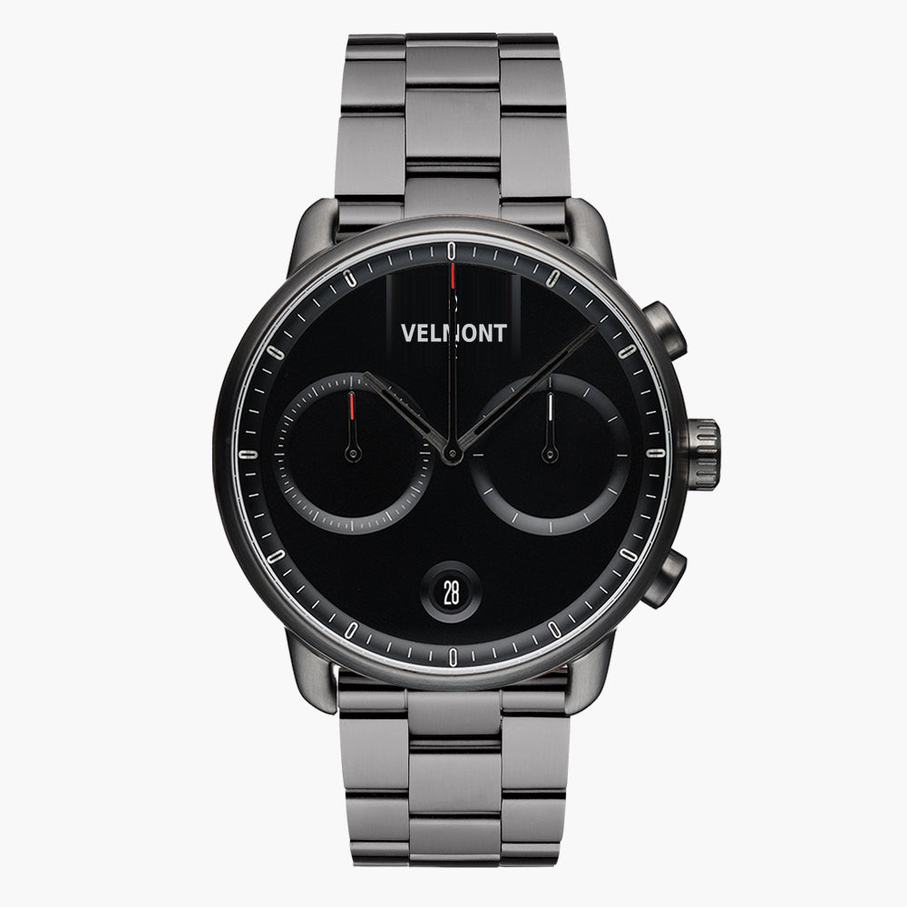 Chronograph-style watch with a black dial on a gunmetal link bracelet, front view.