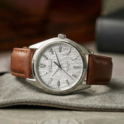 Silver bark-dial watch lying on a gray cloth