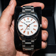 White dial watch held in an open box