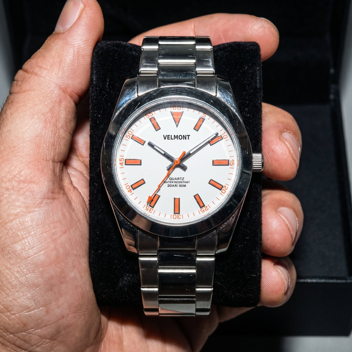 White dial watch held in an open box