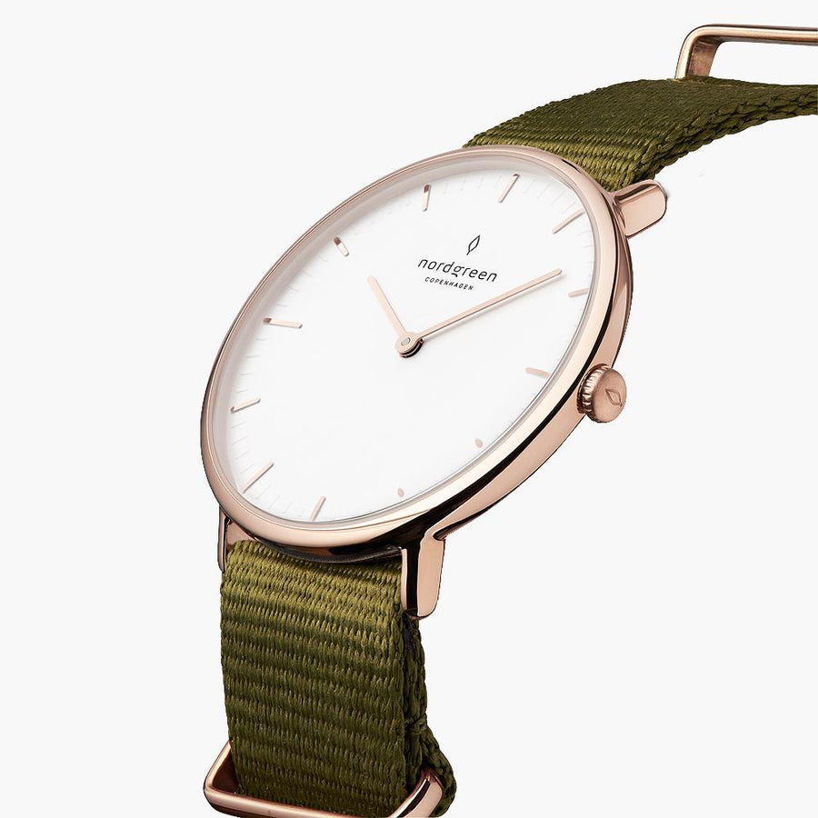 Three-quarter view of the thin rose gold-tone case on a green fabric strap.