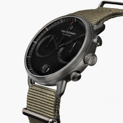 Angled view of the black dial, red accents and gunmetal pushers.