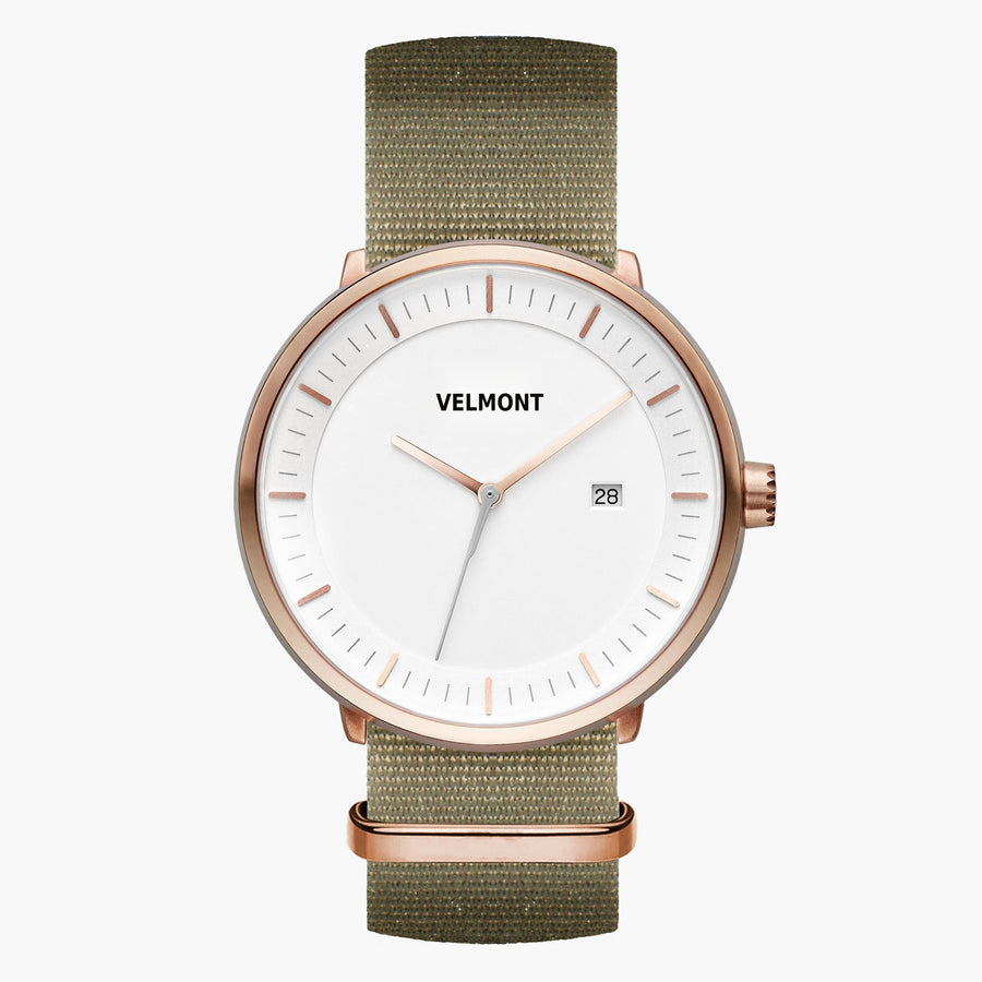 Watch with a white dial and rose gold-tone case on an olive green woven strap.