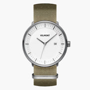 Watch with a white dial and gunmetal case on an olive green woven strap.