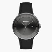 Watch with a dark gray sunburst dial and gunmetal case on a black strap.